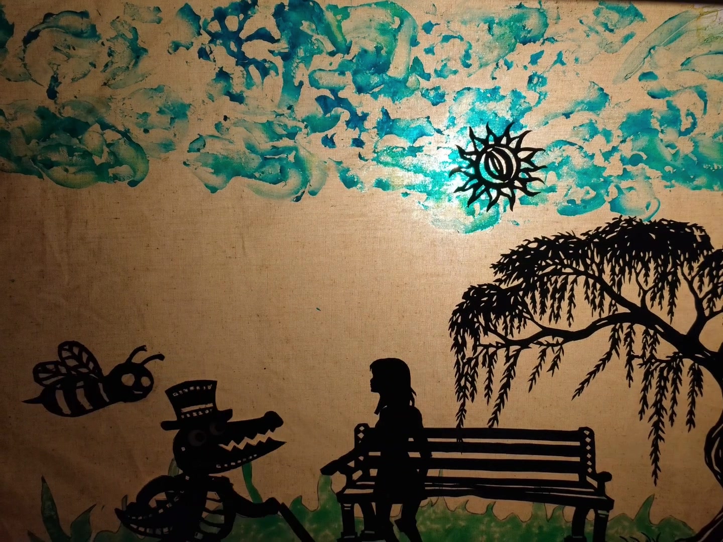 Shadow puppet still — a top-hatted crocodile and a figure on a bench under a watercolour sky